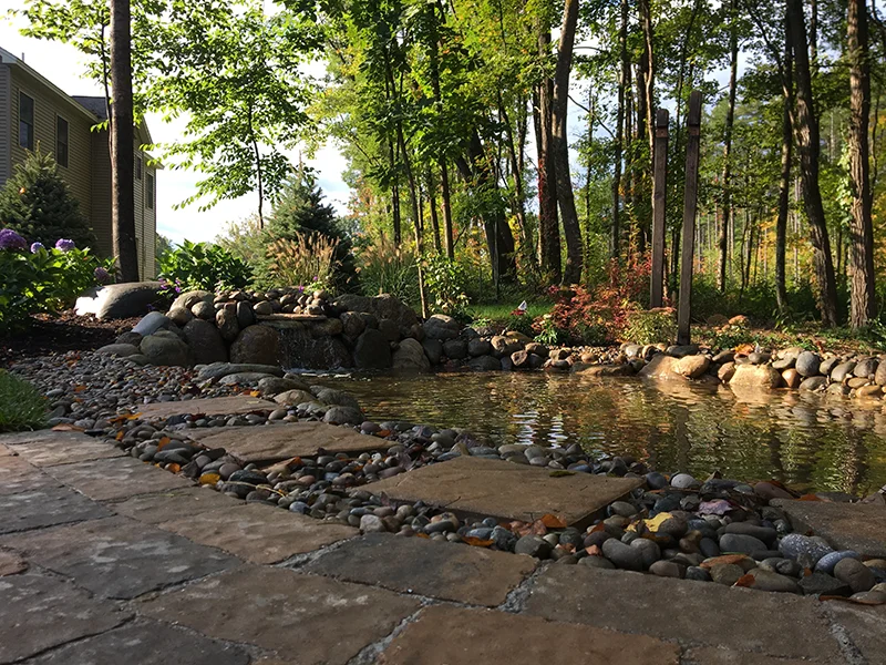 After: completed paver patio and pond feature by Bollman Landscape